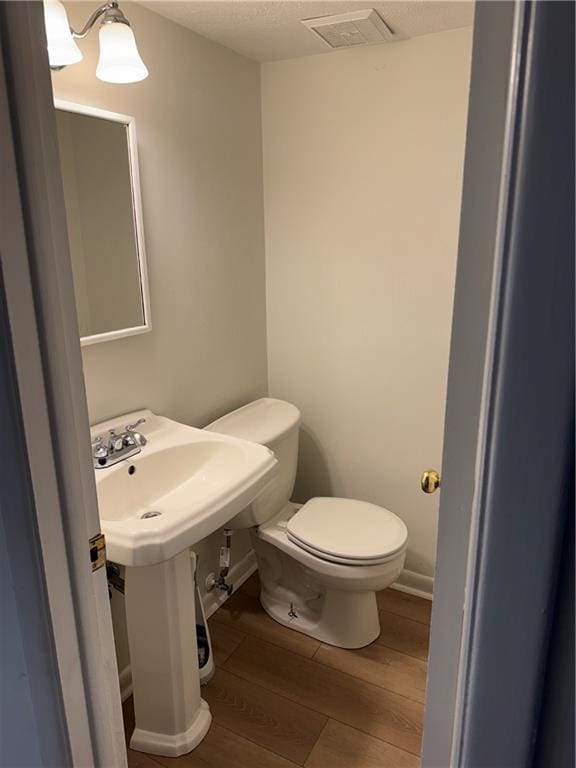 bathroom with wood-type flooring and toilet