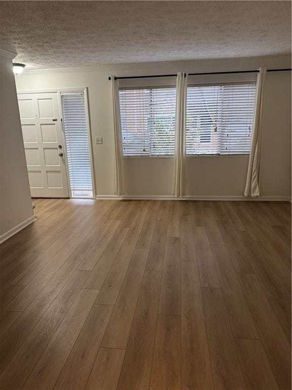 interior space with a textured ceiling and light hardwood / wood-style flooring