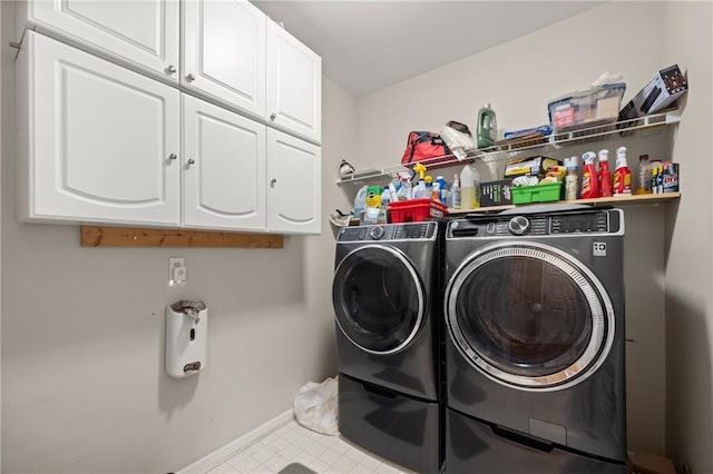 clothes washing area featuring cabinets and independent washer and dryer