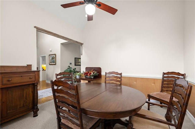 carpeted dining room with ceiling fan