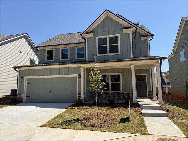 309 Ridge Pointe Dr, Athens, GA 30606 - view of front of property featuring board and batten siding, covered porch, brick siding, dirt driveway, and a garage