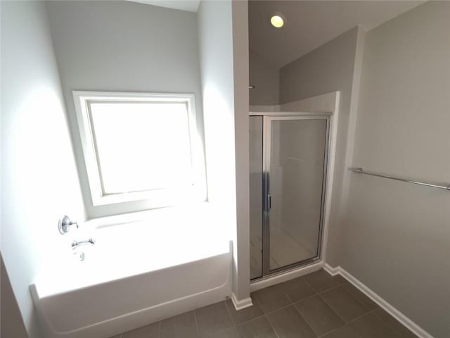 full bathroom with a garden tub, a stall shower, tile patterned flooring, baseboards, and vaulted ceiling