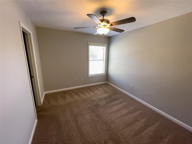 carpeted empty room with ceiling fan and baseboards