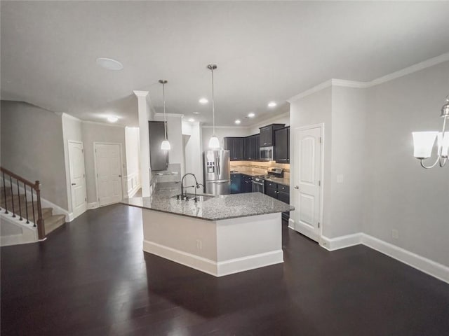 kitchen with baseboards, light stone countertops, a peninsula, appliances with stainless steel finishes, and a sink