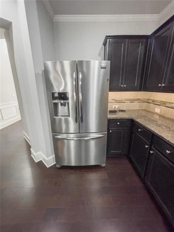 kitchen with backsplash, stainless steel fridge with ice dispenser, ornamental molding, light stone counters, and dark wood-style flooring