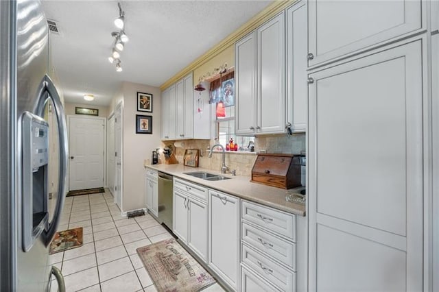 kitchen featuring light tile patterned flooring, sink, stainless steel appliances, and tasteful backsplash