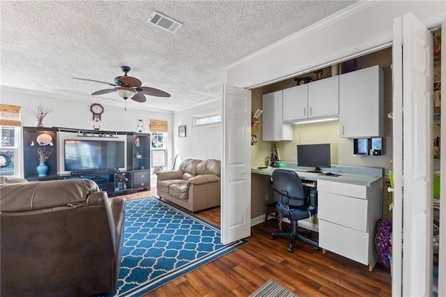 office space featuring a textured ceiling, ceiling fan, ornamental molding, and dark wood-type flooring