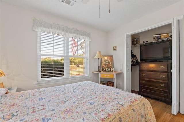 bedroom featuring ceiling fan, a closet, and light hardwood / wood-style flooring