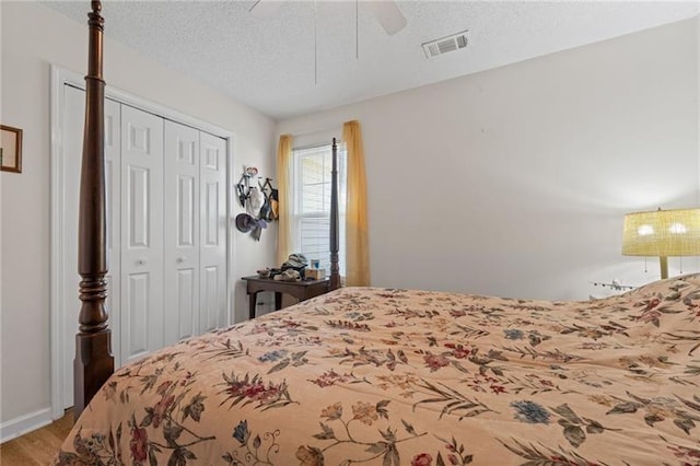 bedroom with ceiling fan, a closet, wood-type flooring, and a textured ceiling