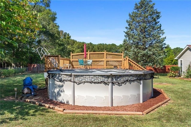 view of swimming pool featuring a wooden deck and a yard