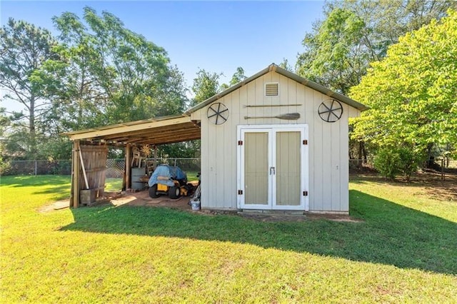 view of outbuilding featuring a lawn and a carport