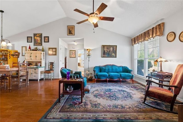 living room featuring ceiling fan with notable chandelier, dark hardwood / wood-style floors, and vaulted ceiling