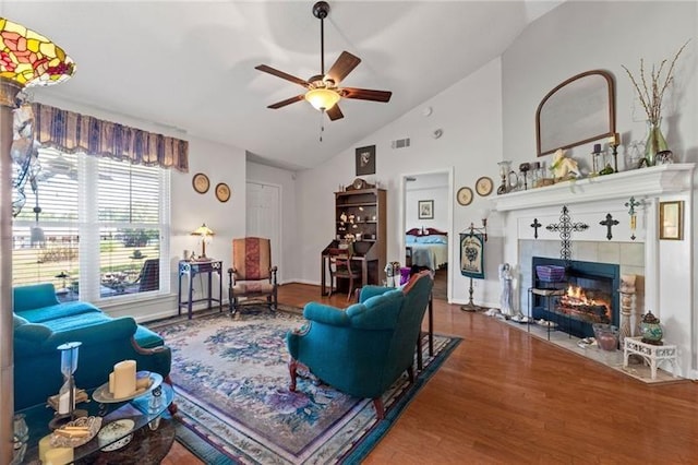 living room featuring a fireplace, hardwood / wood-style flooring, vaulted ceiling, and ceiling fan