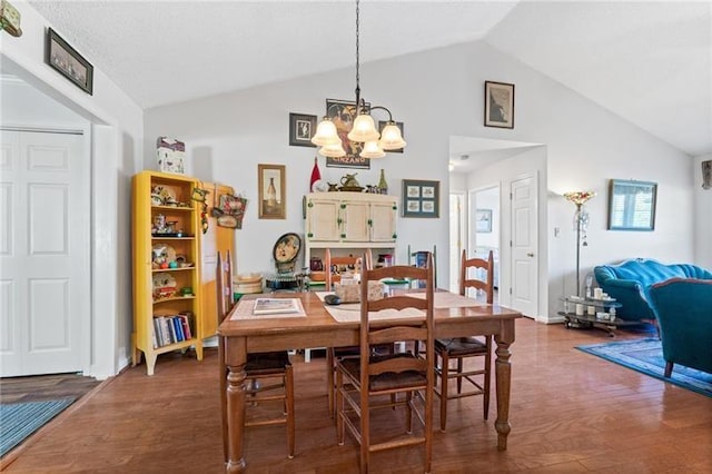 dining space with vaulted ceiling, wood-type flooring, and an inviting chandelier