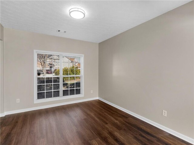 spare room with dark hardwood / wood-style flooring