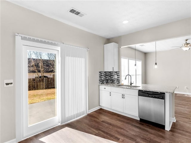 kitchen with tasteful backsplash, stainless steel dishwasher, sink, decorative light fixtures, and white cabinets