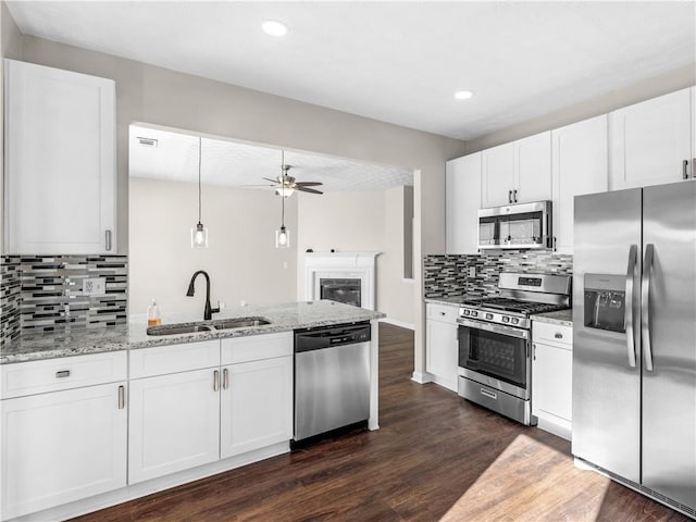 kitchen with dark wood-type flooring, sink, appliances with stainless steel finishes, tasteful backsplash, and white cabinetry