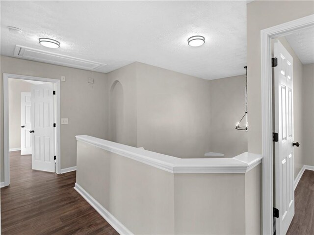 hall with dark hardwood / wood-style flooring and a textured ceiling