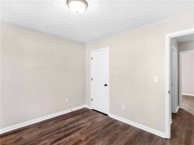 unfurnished room with dark hardwood / wood-style floors