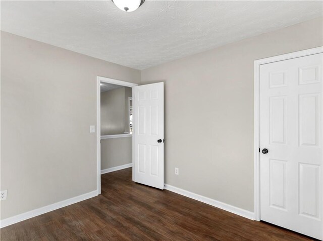 unfurnished room with dark hardwood / wood-style flooring