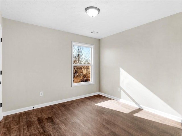 spare room with dark wood-type flooring