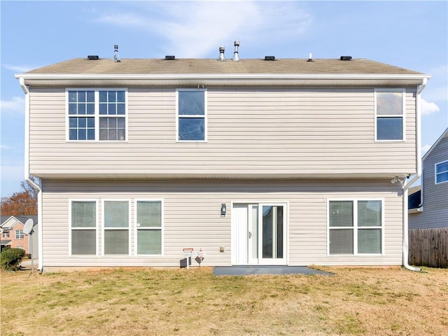 rear view of property featuring a lawn