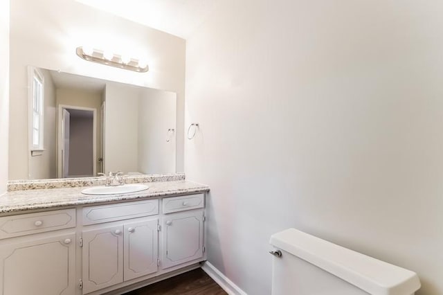 4820 Oak Grove Dr, Cumming, GA 30040 - half bath featuring toilet, vanity, wood finished floors, and baseboards