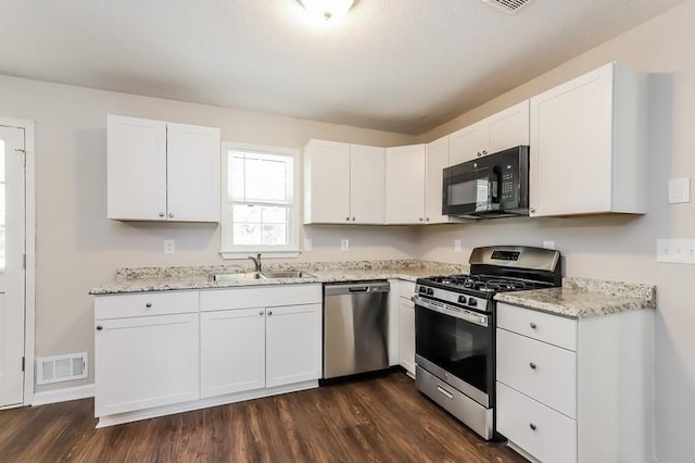 4820 Oak Grove Dr, Cumming, GA 30040 - kitchen featuring stainless steel appliances, a sink, dark wood-style flooring, and white cabinetry