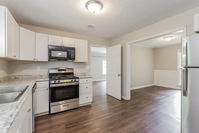 4820 Oak Grove Dr, Cumming, GA 30040 - kitchen featuring appliances with stainless steel finishes, dark wood finished floors, white cabinets, and a sink