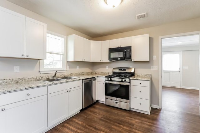 4820 Oak Grove Dr, Cumming, GA 30040 - kitchen with appliances with stainless steel finishes, a sink, dark wood-style floors, and white cabinets