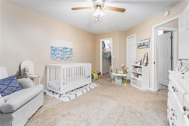 bedroom with carpet flooring, a ceiling fan, and a textured ceiling