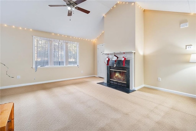 unfurnished living room with baseboards, high vaulted ceiling, a fireplace with flush hearth, ceiling fan, and light carpet