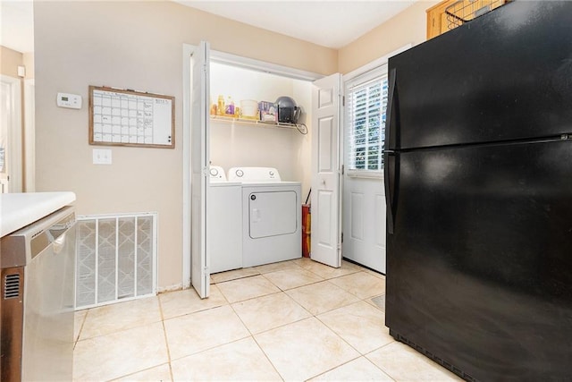 laundry room featuring light tile patterned floors, laundry area, washer and clothes dryer, and visible vents