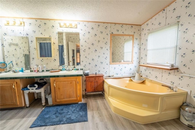735 Hale Rd, Maysville, GA 30558 - full bathroom featuring wallpapered walls, crown molding, wood finished floors, a textured ceiling, and double vanity