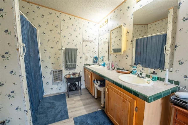 735 Hale Rd, Maysville, GA 30558 - full bathroom featuring wallpapered walls, a textured ceiling, heating unit, wood finished floors, and double vanity