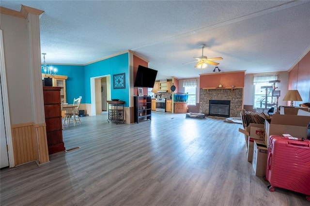 735 Hale Rd, Maysville, GA 30558 - living room with a textured ceiling, wood finished floors, a ceiling fan, a fireplace, and a chandelier
