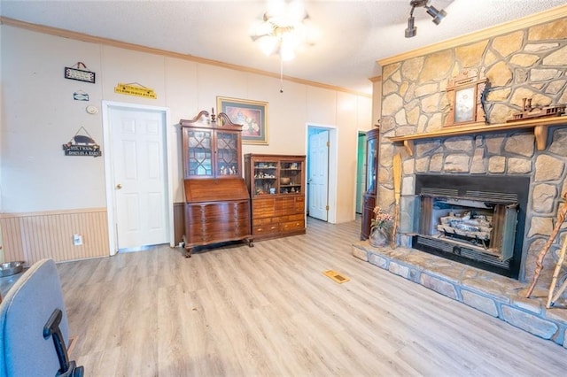 735 Hale Rd, Maysville, GA 30558 - living area featuring ornamental molding, wood finished floors, a stone fireplace, and a textured ceiling