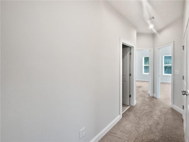 hall featuring light colored carpet