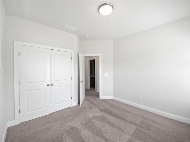 unfurnished bedroom with light carpet and a closet