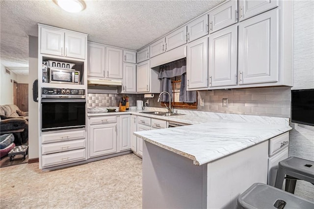 5843 Foxfield Trl, Rex, GA 30273 - kitchen with oven, a sink, a peninsula, tasteful backsplash, and a textured ceiling