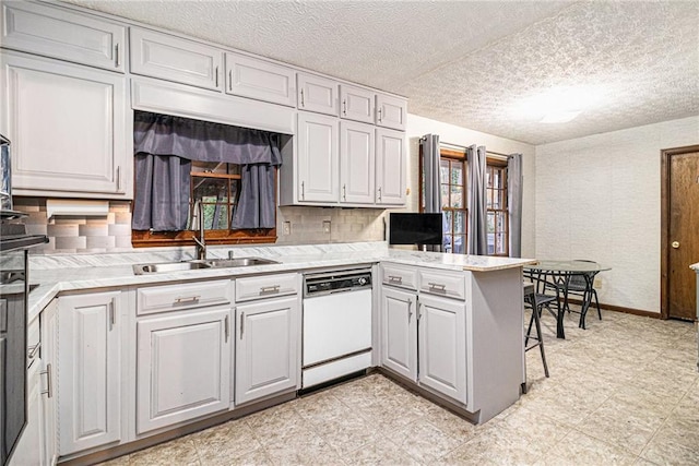 5843 Foxfield Trl, Rex, GA 30273 - kitchen featuring dishwasher, a sink, light countertops, tasteful backsplash, and a textured ceiling