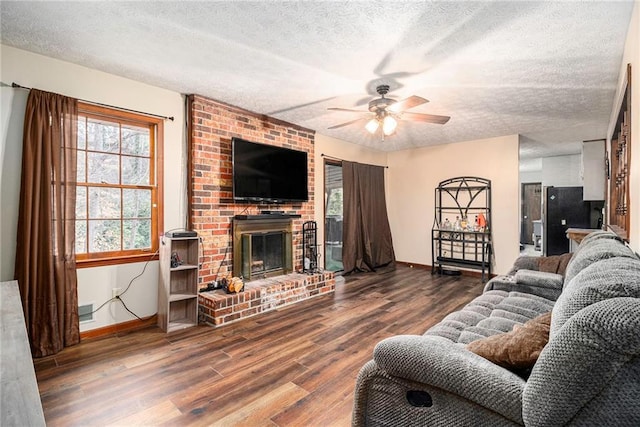 5843 Foxfield Trl, Rex, GA 30273 - living area with ceiling fan, baseboards, a textured ceiling, wood finished floors, and a brick fireplace