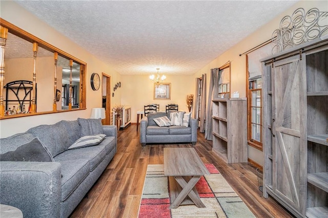 5843 Foxfield Trl, Rex, GA 30273 - living room with wood finished floors, a chandelier, a textured ceiling, and a barn door