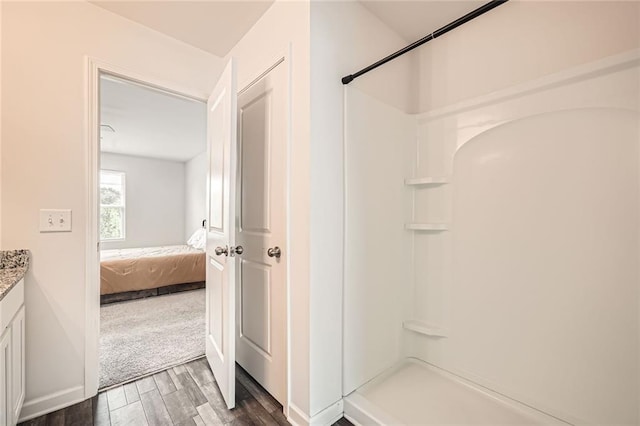 bathroom with walk in shower, wood finished floors, ensuite bathroom, and vanity