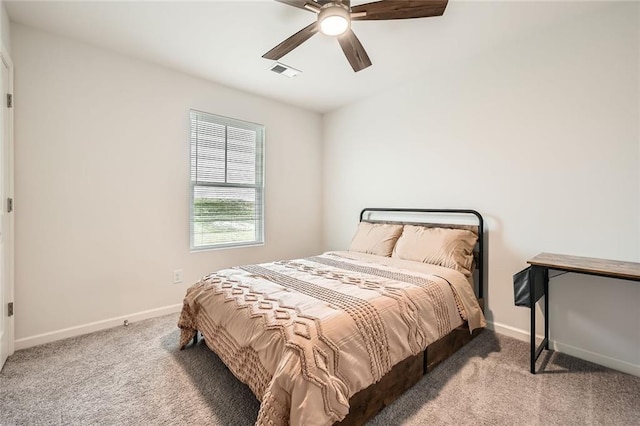 carpeted bedroom featuring baseboards, a ceiling fan, and visible vents