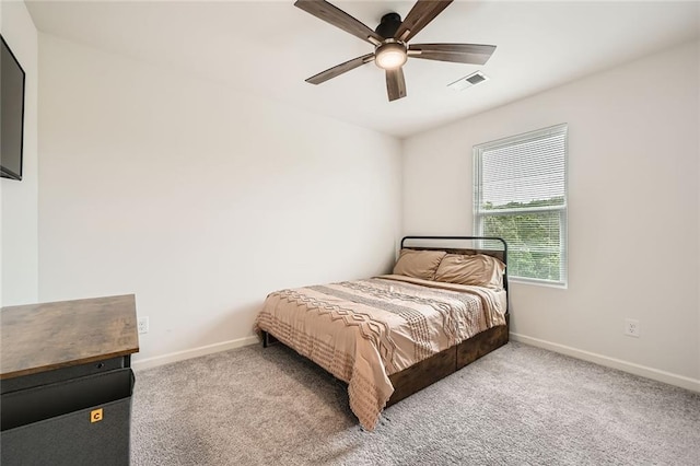 carpeted bedroom with visible vents, baseboards, and ceiling fan