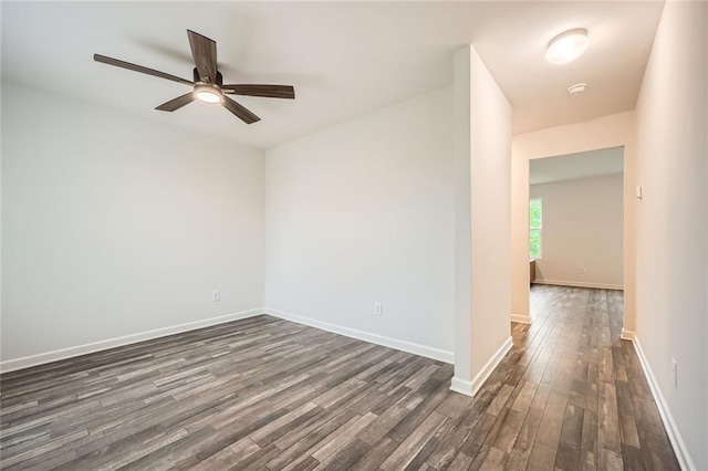 empty room featuring baseboards, dark wood finished floors, and ceiling fan