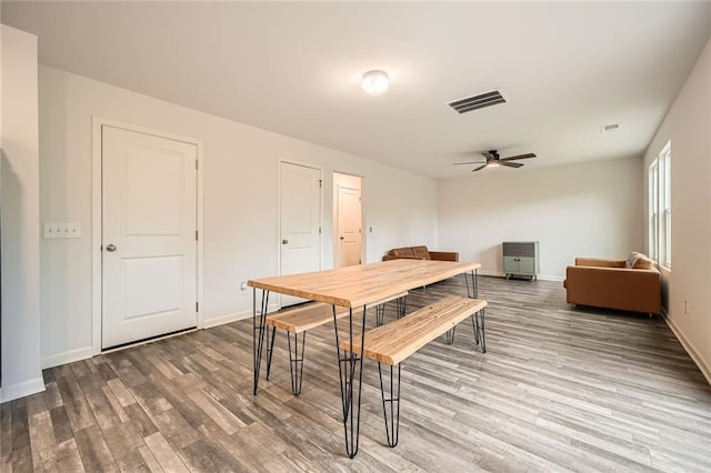dining space featuring a ceiling fan, baseboards, visible vents, and wood finished floors