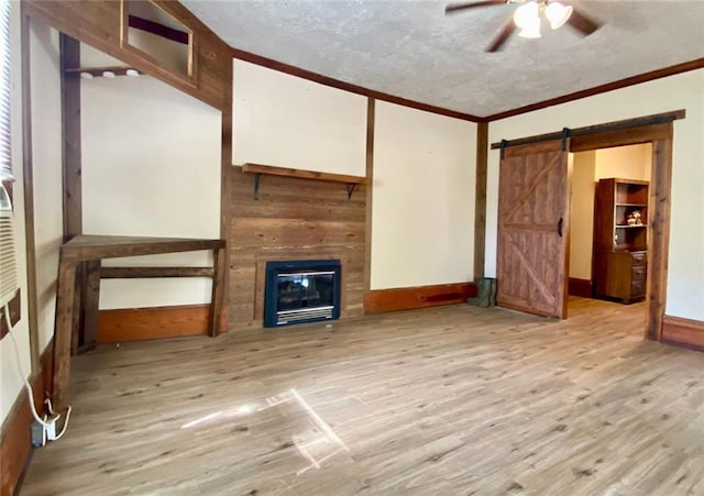 505 Sandhill Hickory Level Rd, Carrollton, GA 30116 - unfurnished living room featuring a glass covered fireplace, ceiling fan, light wood-style floors, crown molding, and a textured ceiling
