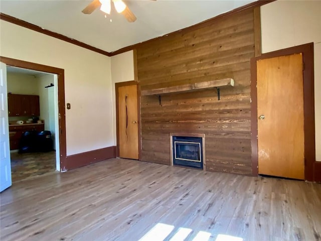 505 Sandhill Hickory Level Rd, Carrollton, GA 30116 - unfurnished living room featuring ceiling fan, a glass covered fireplace, wood finished floors, wood walls, and crown molding